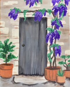 A wooden door on a stone wall with purple flowering vines, and potted plants on the ground.